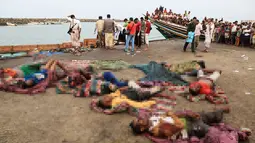 Warga melihat jenazah pengungsi Somalia yang tewas akibat serangan sebuah helikopter di lepas pantai Yaman, Jumat (17/3). Para pengungsi yang dilengkapi dokumen resmi UNHCR tersebut sedang dalam dalam perjalanan dari Yaman ke Sudan. (AFP Photo/STR)