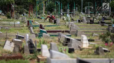 Petugas makam membersihkan area pemakaman di Tempat Pemakaman Umum (TPU) Utan Jati, Jakarta, Kamis (11/1). Pemprov DKI Jakarta menyiapkan anggaran Rp 400 miliar untuk pengadaan lahan makam TPU pada tahun ini. (Liputan6.com/Faizal Fanani)