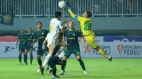 Pemain Persija Jakarta, Aji Kusuma (kiri) berebut bola dengan kiper Persikabo 1973, Syahrul Trisna pada laga pekan kedua BRI Liga 1 2023/2024 di Stadion Pakansari, Cibinong, Bogor, Minggu (9/7/2023). (Bola.com/M Iqbal Ichsan)