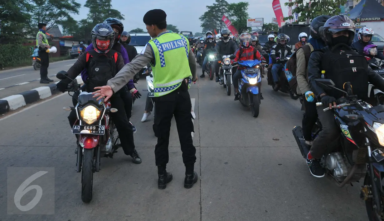 Petugas mengatur kendaraan yang terjebak kemacetan di jalan Lamaran, Karawang, Sabtu (2/7). Kemacetan tersebut terjadi akibat pemisahan jalur antara roda dua dengan roda empat untuk mengantisipasi jalur mudik Pantura. (Liputan6.com/Gempur M Surya)
