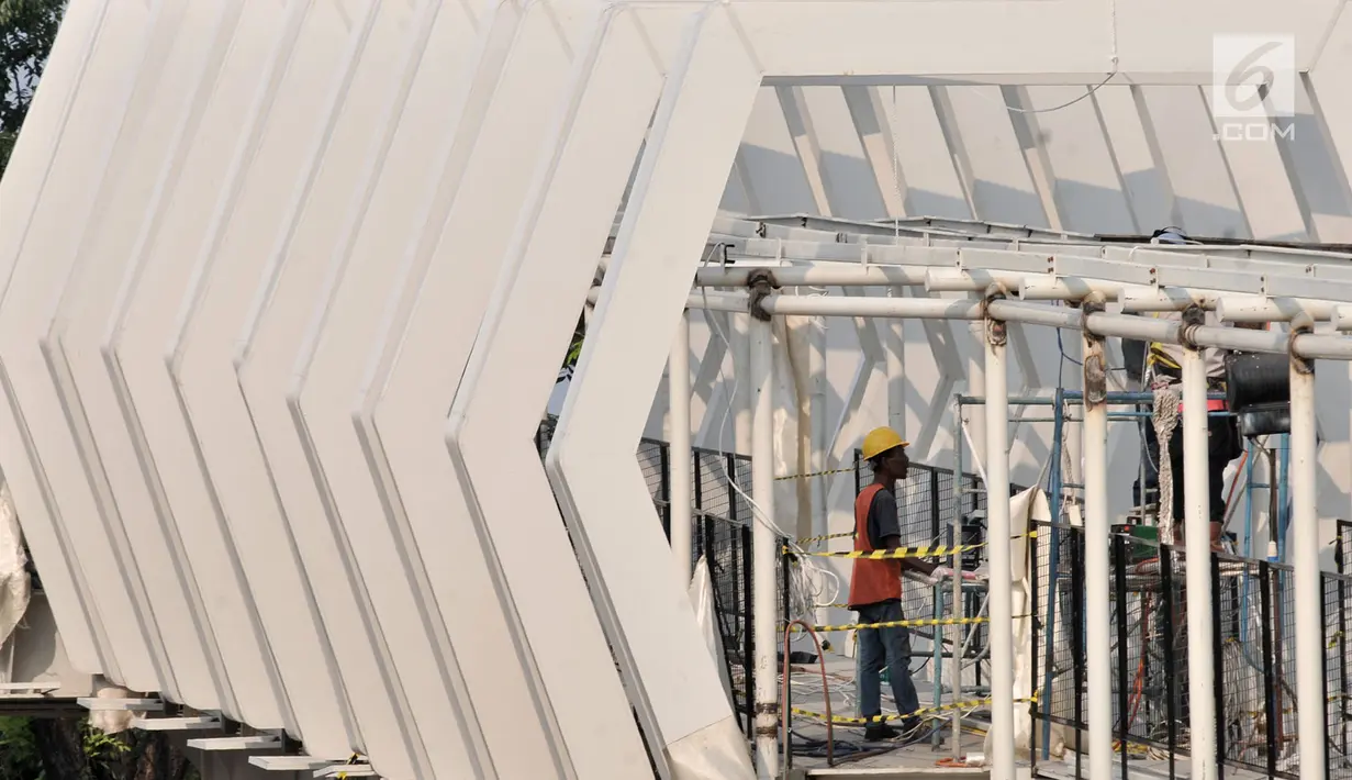Pekerja menyelesaikan pembangunan Skybridge Stasiun LRT Velodrome-Halte Transjakarta Pemuda, Jakarta, Selasa (11/6/2019). Pengoperasian LRT Kelapa Gading-Velodrome kembali diundur karena belum selesainya pembangunan Skybridge LRT Velodrome-Halte Transjakarta Pemuda. (merdeka.com/Iqbal Nugroho)