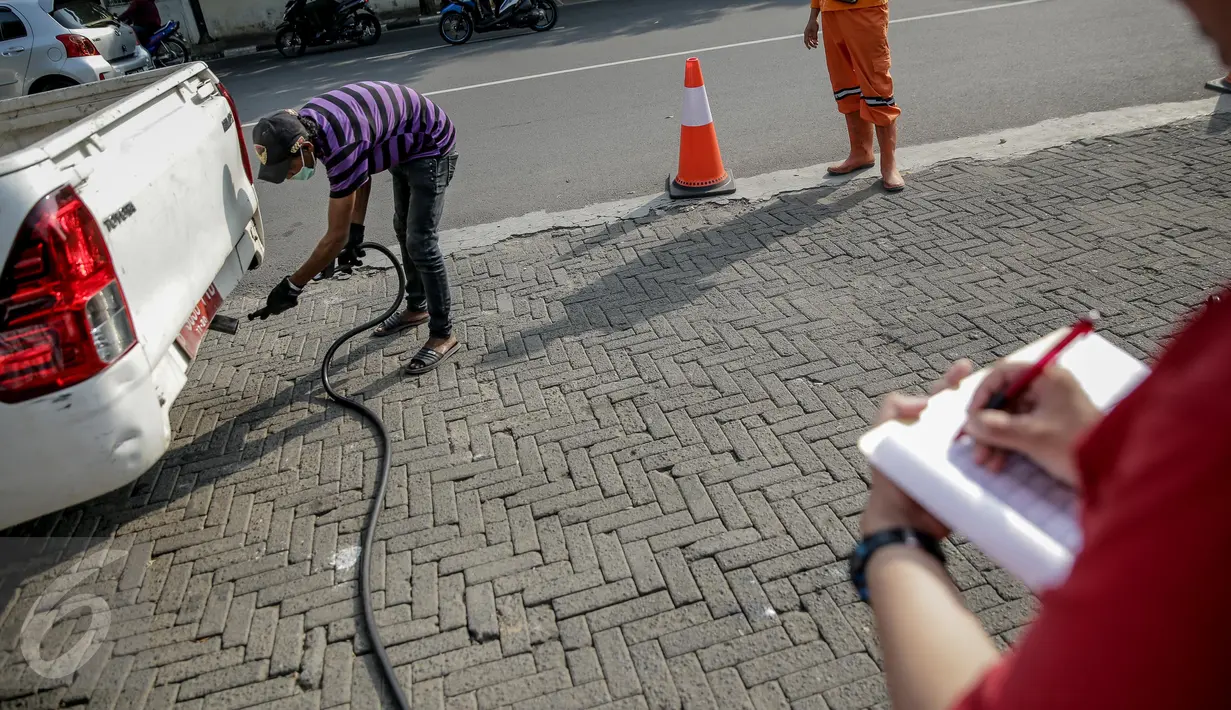 Petugas melakukan pengujian asap saat uji emisi kendaraan bermotor di kawasan Tugu Proklamasi, Jakarta, Selasa (16/5). Suku Dinas Lingkungan Hidup Jakarta Pusat menggelar uji emisi guna menekan angka polusi kendaraan. (Liputan6.com/Faizal Fanani)