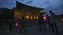 Pengunjung memegang lentera tradisional Korea berjalan-jalan selama Tur Cahaya Bulan di Istana Changdeokgung di Seoul, Korea Selatan, Kamis, (13/8/2020). Istana dibuka kembali pada Kamis setelah ditutup selama dua bulan karena pandemi Covid-19. (AP Photo/Ahn Young-joon)