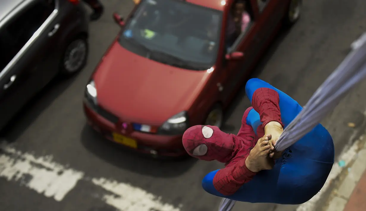 Jahn Fredy Duque beraksi di jalanan Bogota, Kolombia, Senin (24/4). Duque mencari nafkah dengan melakukan atraksi layaknya Spiderman. (AFP Photo/RAUL ARBOLEDA)