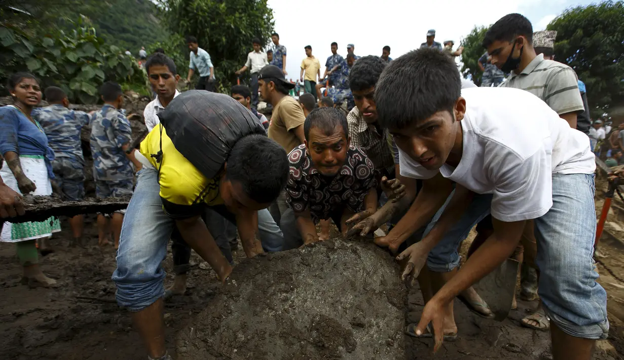 Warga menggeser batu untuk mencari korban yang tertimbun bangunan pasca longsor di Desa Lumle, Nepal (30/7/2015). Tanah longsor yang dipicu hujan deras tersebut menewaskan sedikitnya 30 orang dan menghacurkan puluhan rumah. (REUTERS/Navesh Chitrakar) 