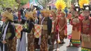 9. Rombongan peserta mengenakan pakaian adat Kalimantan Tengah saat mengikuti rangkaian acara Festival Budaya Isen Mulang di Bundaran Palangkaraya, Minggu (19/5/24) pagi. (Bola.com/Ade Yusuf Satria)