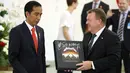 Perdana Menteri Denmark Lars Lokke Rasmussen memberikan Presiden Joko Widodo (Jokowi) cendera mata piringan hitam band Metallica usai pernyataan bersama dalam kunjungan kerja PM Denmark di Istana Bogor, Jawa Barat, Selasa (28/11). (AP/Dita Alangkara)