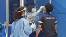 Seorang petugas medis mengambil sampel dari petugas polisi selama pengujian COVID-19 di Badan Kepolisian Metropolitan Seoul di Seoul, Korea Selatan, Rabu, (19/8/2020). (AP Photo / Ahn Young-joon)