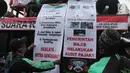 Pengemudi ojek online membentangkan poster yang berisi tuntutan mereka saat melakukan aksi di seberang Istana Merdeka, Jakarta, Selasa (27/3). (Liputan6.com/Arya Manggala)