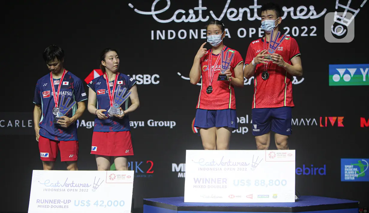 Pebulu tangkis ganda campuran China Zheng Si Wei/Huang Ya Qiong (kanan) dan pebulu tangkis ganda campuran Jepang Yuta Watanabe/Arisa Higashino (kiri) naik podium usai pertandingan final East Ventures Indonesia Open 2022 di Istora, Senayan, Jakarta, Minggu (19/6/2022). Zheng Si Wei/Huang Ya Qiong menjuarai Indonesia Open 2022 usai mengalahkan Yuta Watanabe/Arisa Higashino dengan skor 21-14 dan 21-16. (Liputan6.com/Faizal Fanani)