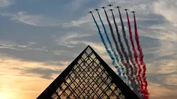 Tim terbang akrobatik Elite Angkatan Udara Prancis "Patrouille de France" tampil di atas Pyramide du Louvre pada Upacara Pembukaan Paralimpiade Paris 2024, Rabu (28/8/2024). (Christophe DELATTRE / AFP)