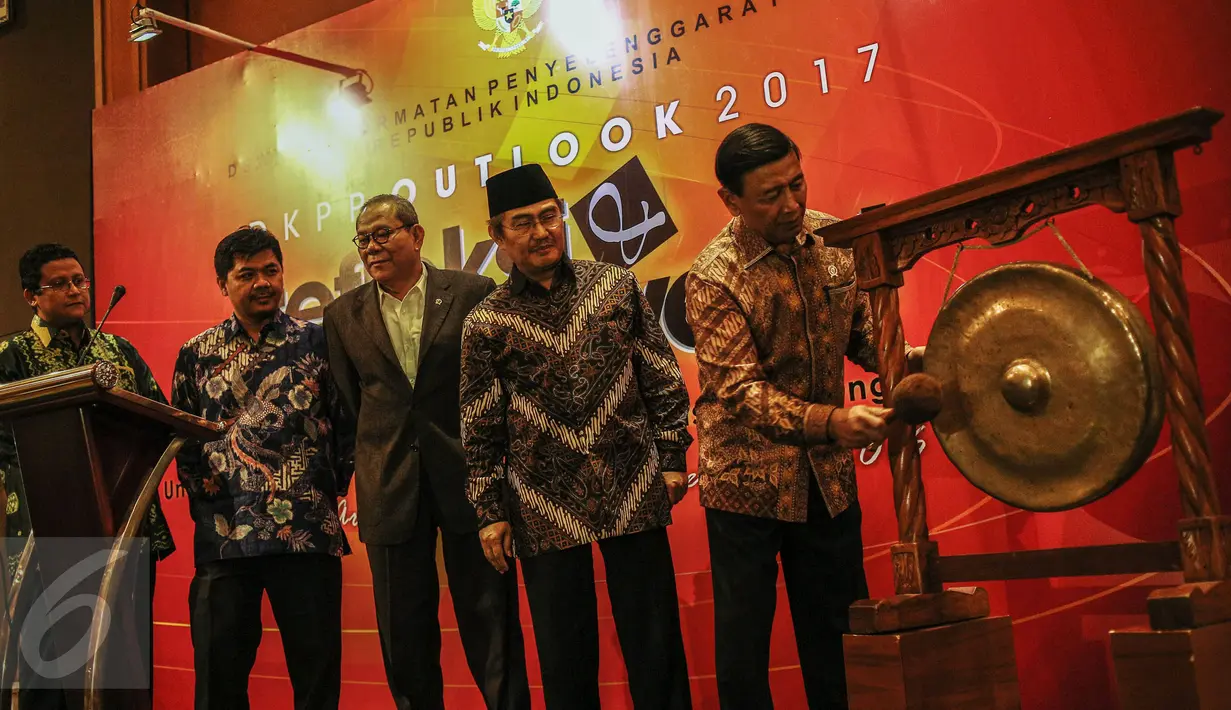 Menko Polhukam Wiranto didampingi Ketua DKPP Jimly Asshiddiqie (kedua kanan) memukul gong sebagai tanda pembukaan kegiatan Outlok 2017 atau Refleksi Akhir Tahun bertajuk Evaluasi dan Proyeksi di Jakarta, Rabu (14/12). (Liputan6.com/Faizal Fanani)
