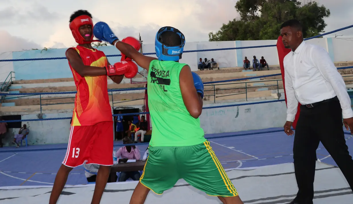 Petinju Somalia bertanding di atas ring di Stadion Wish, Mogadishu pada 15 November 2018. Pertandingan setelah Somalia pulih dari perang saudara itu digelar di lapangan basket yang disulap menjadi area pertarungan. (Abdirazak Hussein FARAH / AFP)