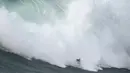 Peselancar Nic von Rupp dari Portugal mengendarai ombak selama kompetisi selancar ombak besar Nazare Tow Challenge di Praia do Norte, atau Pantai Utara, di Nazare, Portugal, Kamis, 10 Februari 2022. (AP Photo/Armando Franca)