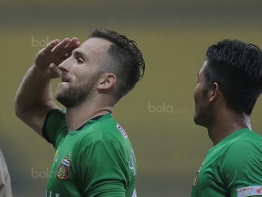 Usai membobol gawang Persela Lamongan, penyerang Bhayangkara FC, Ilija Spasojevic memberikan hormat kepada bendera Merah-Putih pada lanjutan Liga 1 2017 di Stadion Patriot, Bekasi, (27/10/2017). Bhayangkara menang 3-1. (Bola.com/Nicklas Hanoatubun)