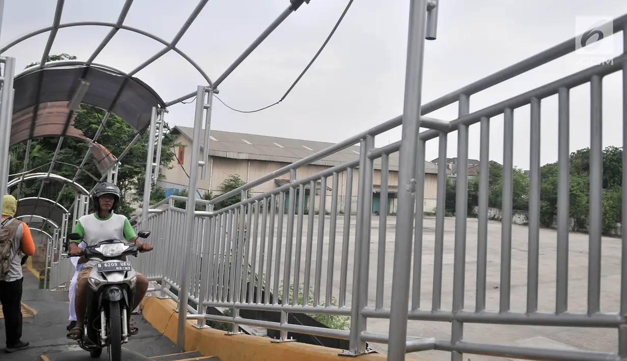 Pejalan kaki menepikan diri saat pengendara sepeda motor melintasi JPO di Jalan Yos Sudarso, Jakarta, Senin (12/11). (Merdeka.com/Iqbal S. Nugroho)
