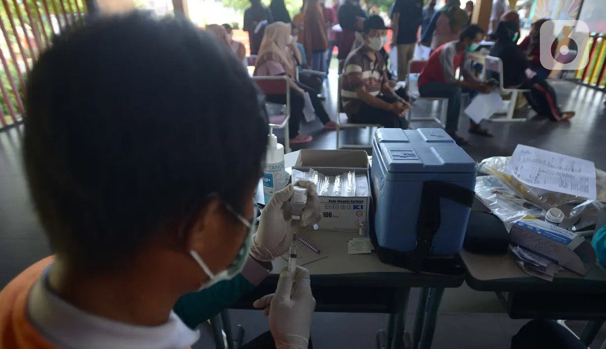 Petugas kesehatan menyiapkan vaksin dosis ketiga (Booster) di RPTRA Kopi Gandaria, Pasar Rebo, Jakarta, Jumat (15/7/2022). Wajibnya vaksin booster terkait terus bertambahnya kasus Covid-19 yakni 3.584 orang pada hari Kamis 14 Juli 2022. (merdeka.com/Imam Buhori)