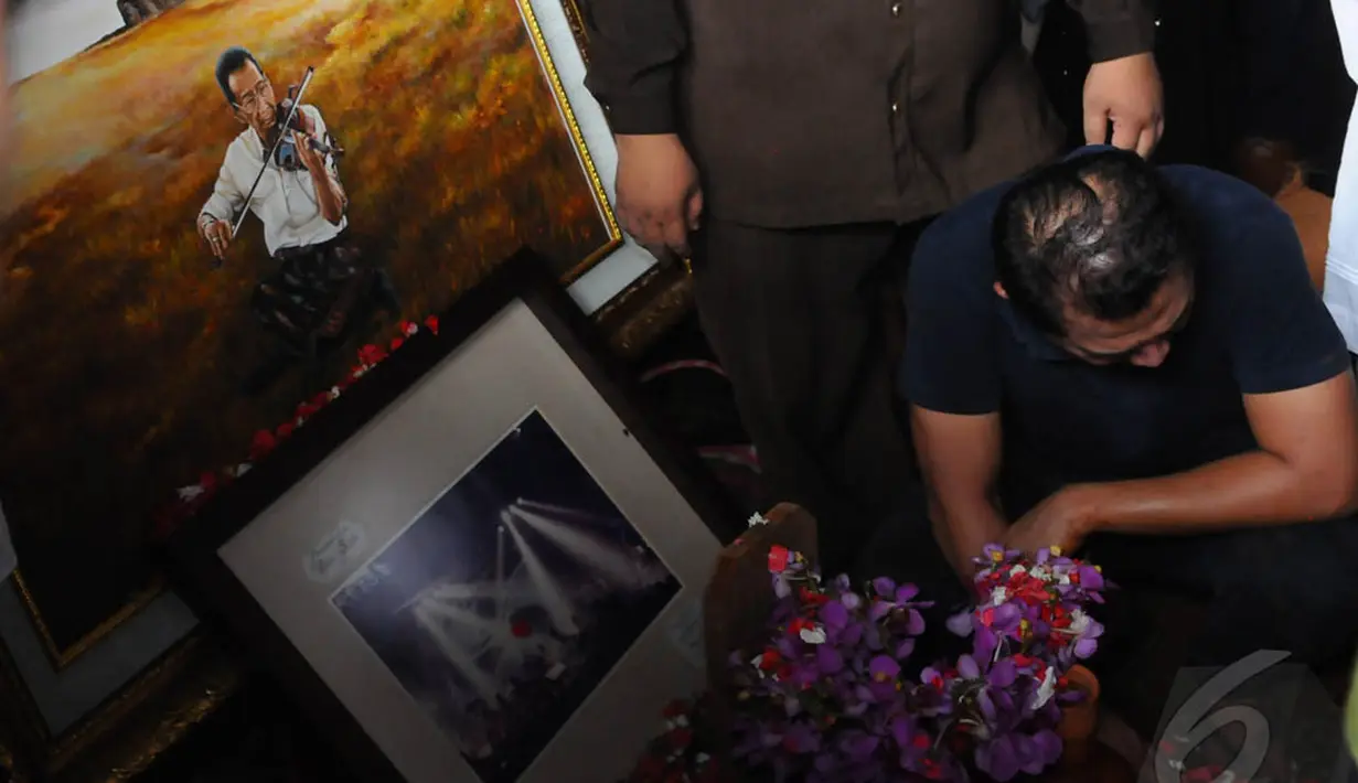 Sebuah lukisan Idris Sardi sedang bermain biola ikut mengiringi kepergian sang Maestro, TPU Menteng Pulo. Jakarta Pusat, Senin (28/04/2014) (Liputan6.com/Andrian M Tunay).