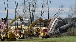 Petugas memindahakan puing-puing dari kecelakaan kereta barang di Georgetown, Kentucky, Amerika Serikat, Senin (19/3). Kecelakaan ini mengakibatkan kebakaran. (AP Photo/Timothy D. Easley)