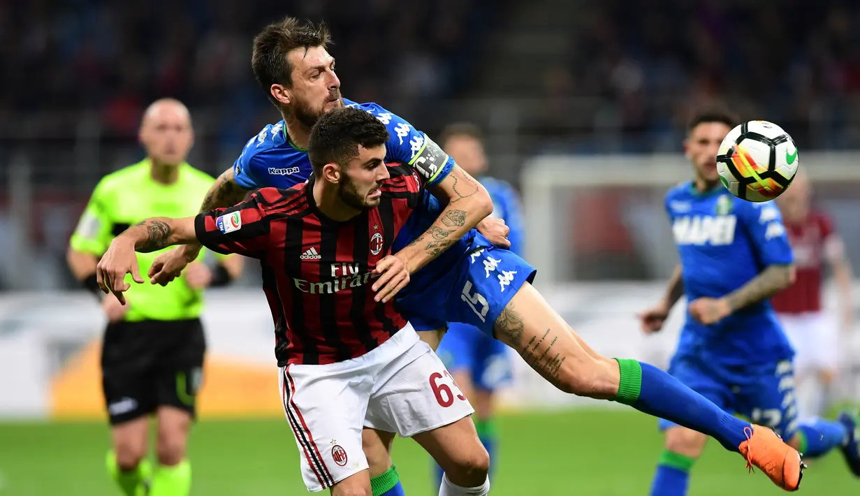 Pemain AC Milan, Patrick Cutrone berebut bola dengan kapten Sassuolo, Francesco Acerbi pada laga pekan ke-31 Serie A di San Siro, Minggu (8/4). Sassuolo menahan AC Milan dengan skor 1-1 dalam lanjutan laga Serie A. (AFP PHOTO/MIGUEL MEDINA)