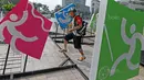 Seorang warga sedang melihat deretan logo olahraga Asian Games 2018 di Bundaran HI, Jakarta, (17/8/2017), Asian Games mengambil tema Energy Of Asia dan akan dibuka oleh Presiden Republik Indonesia Joko Widodo. (Bola.com/Nicklas Hanoatubun)