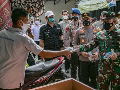 Pangdam Jaya Mayjen TNI Dudung Abdurrachman (kanan) dan Kapolda Metro Jaya Irjen Pol Fadil Imran membagikan masker kepada warga di Sunter Muara, Tanjung Priok, Jakarta, Selasa (9/2/2021). Kegiatan ini untuk menyadarkan masyarakat akan pentingnya penggunaan masker. (Liputan6.com/Faizal Fanani)