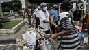 Petugas membagikan takjil kepada pedagang keliling secara drive thru di Kompleks Masjid Al-Azhar, Jakarta, Selasa (13/4/2021). Pengelola Masjid Al-Azhar menyiapkan 500 bungkus takjil per hari yang dibagikan secara drive thru guna mencegah penyebaran COVID-19. (merdeka.com/Iqbal S. Nugroho)