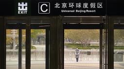 Seorang pekerja yang mengenakan masker berdiri di luar pintu keluar dari stasiun kereta bawah tanah untuk menghentikan pengunjung pergi ke resor Universal Studios Beijing, yang menurut pemberitahuan ditutup untuk pengendalian epidemi, di Beijing, Rabu (26/10/2022). Kota Shanghai di China mulai memberikan vaksin COVID-19 yang dapat dihirup pada hari Rabu di tempat yang tampaknya menjadi yang pertama di dunia. (AP/Mark Schiefelbein)