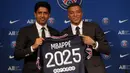 Striker Paris Saint-Germain (PSG) Kylian Mbappe (kanan) menunjukkan jerseynya dengan Presiden PSG Nasser Al-Khelaifi saat konferensi pers di Stadion Paris des Princes, Paris, Prancis, 23 Mei 2022. Keputusan Kylian Mbappe menolak Real Madrid dan berkomitmen untuk PSG selama tiga musim lagi menandai dimulainya proyek pembangunan klub juara Liga Prancis tersebut. (AP Photo/Michel Spingler)