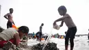 Sejumlah anak terlihat asyik bermain pasir di Pantai Ancol, Jakarta, (30/7/2014). (Liputan6.com/Faizal Fanani)