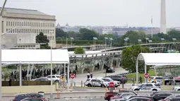 Latar belakang Monumen Washington terlihat saat kendaraan polisi berada di luar area Metro Pentagon, Pentagon, Washington, Amerika Serikat, Selasa (3/8/2021). Penembakan terjadi di sebuah terminal stasiun kereta bawah tanah yang terletak di luar gedung Pentagon. (AP Photo/Andrew Harnik)