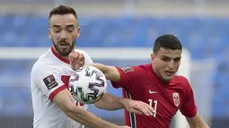 Striker Turki, Kenan Karaman (kanan) berebut bola dengan gelandang Norwegia, Mohamed Elyounoussi dalam laga Kualifikasi Piala Dunia 2022 Zona Eropa Grup G di La Rosaleda Stadium, Malaga, Sabtu (27/3/2021). Turki menang 3-0 atas Norwegia. (AFP/Jorge Guerrero)