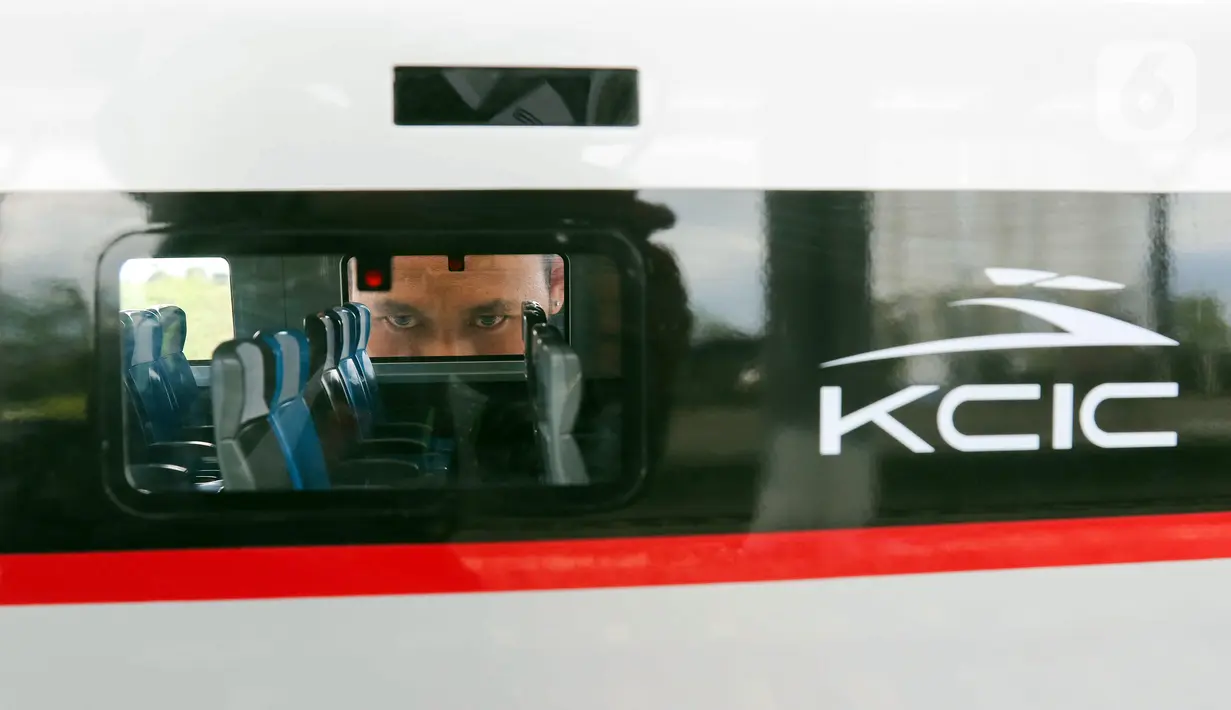 Seorang pria melihat ke dalam maket rangkaian kereta cepat di Stasiun Tegalluar, Kabupaten Bandung, Jawa Barat, Kamis (13/10/2022). Progres pembangunan proyek Kereta Cepat Jakarta-Bandung telah mencapai 88,8 persen dan direncanakan beroperasi pada Juli 2023. (Liputan6.com/Herman Zakharia)