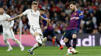 Gelandang Real Madrid, Toni Kroos berusaha merebut bola yang dibawa Striker Barcelona, Lionel Messi selama pertandingan lanjutan La Liga Spanyol di Santiago Bernabeu, Madrid (2/3). Barcelona menang tipis atas Real Madrid 1-0. (AP Photo/Andrea Comas)