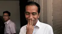 Sedikit tersenyum, Presiden terpilih 2014-2019, Joko Widodo, menutup mulutnya dengan tiga jari, usai menjawab beberapa pertanyaan wartawan di rumah transisi Jokowi-JK di Jakarta, (9/8/2014). (Liputan6.com/Johan Tallo) 