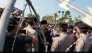 Pimpinan Ponpes Al-Zaytun Panji Gumilang mendekat ke kawat berduri yang dipasang polisi saat pondok pesantren tersebut didemo massa. (Liputan6.com/ Dok Ist)