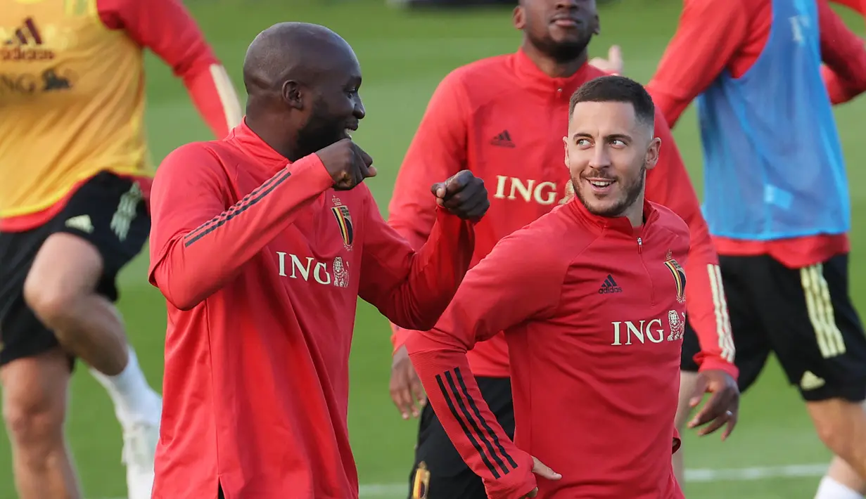 Penyerang Belgia, Romelu Lukaku (kiri) berbincang dengan gelandang Eden Hazard selama sesi latihan di Tubize (5/10/2021). Belgia akan bertanding melawan Prancis pada semifinal UEFA Nations League di Allianz Stadium. (AFP/Belga/Virginie Lefeour)