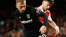 Pemain West Ham United Jarrod Bowen (kiri) berduel memperebutkan bola dengan pemain Arsenal Kieran Tierney pada pertandingan sepak bola Liga Inggris di Emirates Stadium, London, Inggris, 26 Desember 2022. Arsenal mengalahkan West Ham United dengan skor 3-1. (AP Photo/David Cliff)