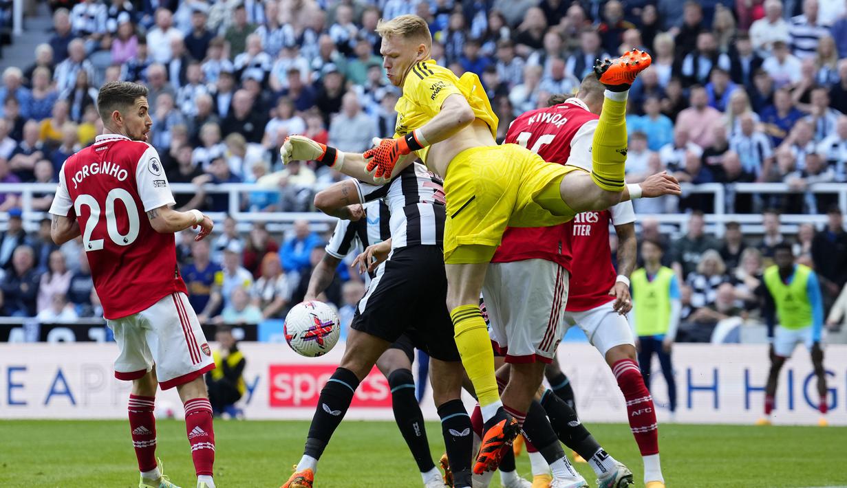 Penjaga gawang Arsenal, Aaron Ramsdale (kiri), berhasil menghalau bola serangan dari pemain Newcastle United dalam laga pekan ke-35 Premier League 2022/2023 yang berlangsung di St James Park, Minggu (7/5/2023). (AP Photo/Jon Super)