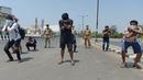 Orang-orang melakukan sit-up tanpa alas kaki sebagai hukuman karena keluar rumah selama pemberlakukan penguncian wilayah (lockdown) di Chennai, Rabu (1/4/2020). Pemerintah India menerapkan kebijakan karantina wilayah atau lockdown dalam memerangi Virus Corona COVID-19. (Arun SANKAR / AFP)