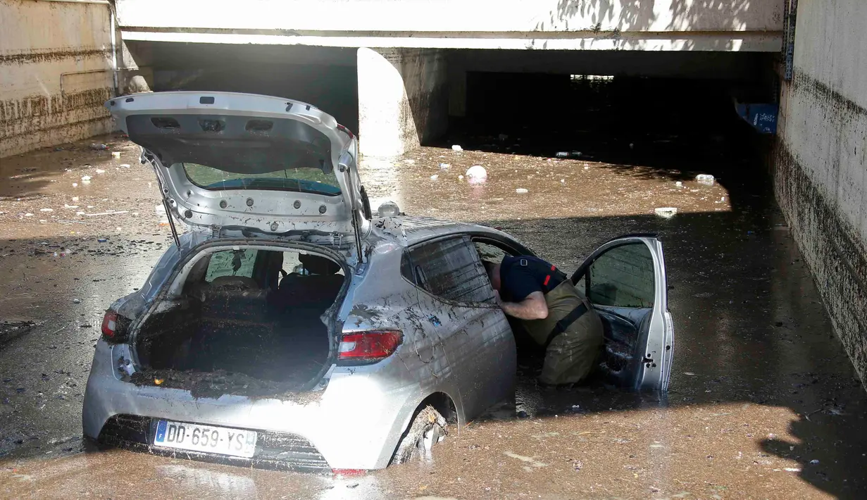 Petugas memeriksa sebuah mobil yang ditinggalkan akibat terendam banjir di Cannes, Prancis, Minggu (4/10/2015). Akibat peristiwa itu, sebanyak 16 warga dilaporkan tewas. (REUTERS/Eric Gaillard)