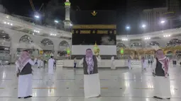 Sejumlah pria membakar dupa di sekitar Ka’bah, Masjidil Haram, Makkah, Arab Saudi, Minggu (26/7/2020). Karena pandemi COVID-19, Arab Saudi membatasi jumlah jemaah haji tahun ini hanya untuk sekitar 1.000 orang. (Saudi Ministry of Media via AP)