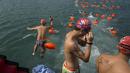 Perenang menyelam sebelum lomba renang lintas pelabuhan di Hong Kong, Minggu (18/10). 2.500 orang ambil bagian dalam menembus jarak lintasan laut sejauh 1,5 km dari Sam Ka Tsuen Public Pier ke Quarry Bay Park Public Pier. (REUTERS/Tyrone Siu)