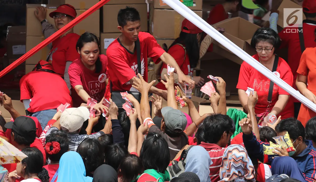 Warga menukarkan kuponnya saat mengikuti acara "Untukmu Indonesia" di lapangan Monas, Jakarta, Sabtu (28/4). Menurut panitia kegiatan pembagian sembako tersebut tidak melanggar aturan karena tidak melakukan aktivitas jual-beli.(Liputan6.com/Arya Manggala)