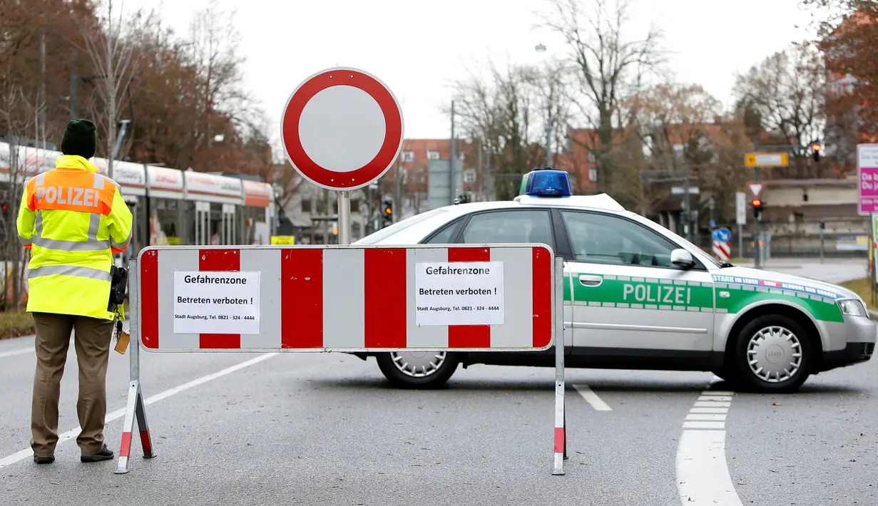 Petugas kepolisian memblokade jalan menyusul evakuasi massal di pusat kota Augsburg, Jerman, Minggu (25/12). Lebih dari 54.000 warga terpaksa dievakuasi setelah ditemukan bom seberat 1,8 ton peninggalan Perang Dunia II. (REUTERS/Michaela Rehle)