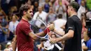 Petenis Swiss, Roger Federer bersalaman dengan John Millman dari Australia usai pertandingan 16 besar AS Terbuka 2018 di New York, (4/9). Federer kalah dari John Millman 3-6, 7-5, 7-6 (9-7), 7-6 (7-3). (AP Photo/Jason DeCrow)