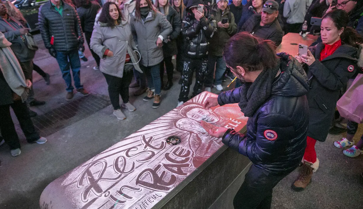 Amir Hussain dari Denmark menggambar menggunakan garam meja untuk memberikan penghormatan kepada mendiang legenda sepak bola Pelé di Times Square di New York pada Kamis, 29 Desember 2022. Sebelum kepergiannya, Pele menjalani perawatan intensif di rumah sakit Albert Einstein, Sao Paulo selama satu bulan terakhir untuk berjuang sembuh dari kanker usus yang dideritanya sejak 2021. (AP Photo/Ted Shaffrey)