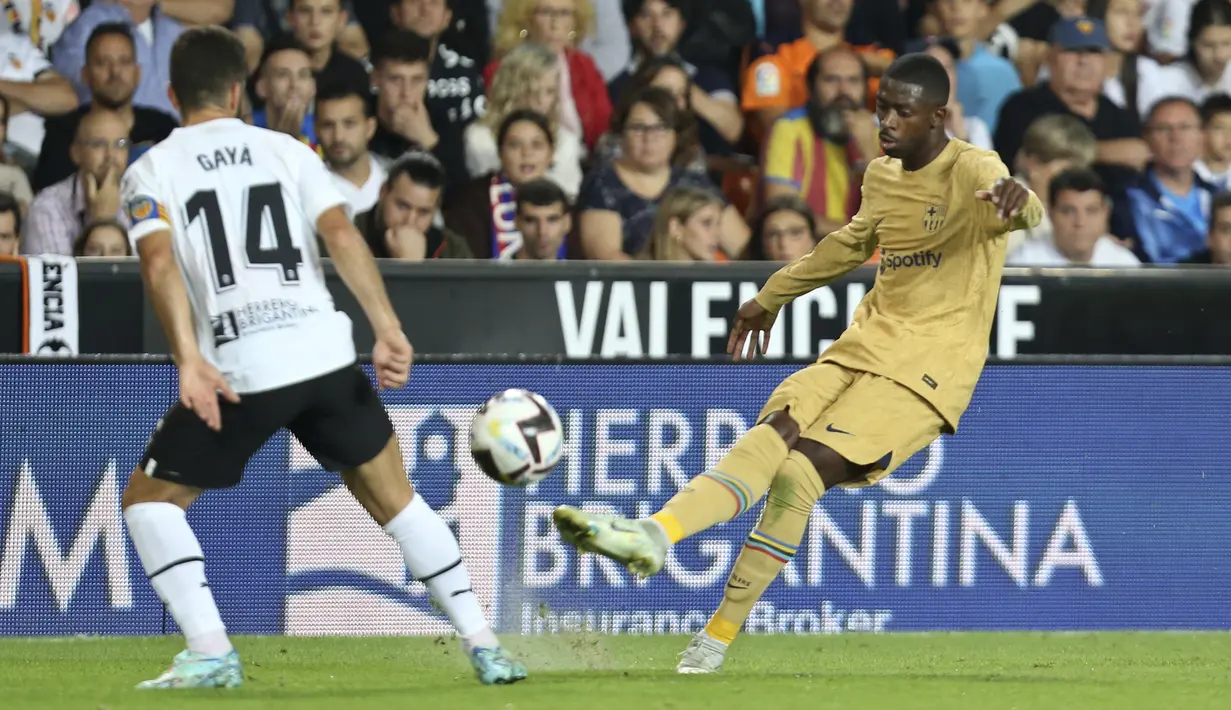 Penyerang Barcelona Ousmane Dembele menendang bola di sebelah bek  Valencia Jose Gaya pada jornada ke-12 La Liga 2022/23 di Mestalla, Minggu (30/10/2022) dini hari WIB. Berkat kemenangan ini Barcelona naik ke puncak klasemen La Liga dengan raihan 31 poin dari 12 laga. (AP Photo/Alberto Saiz)