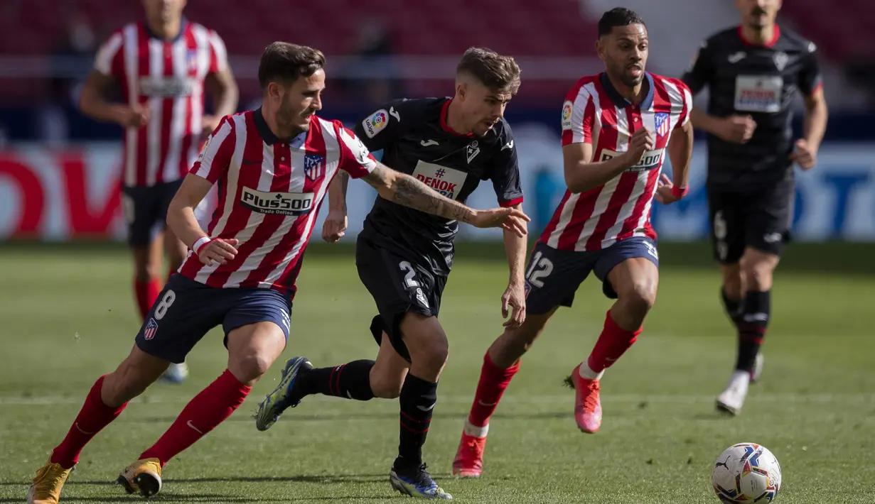 Gelandang Atletico Madrid, Saul (kiri) berebut bola dengan bek Eibar, Esteban Burgos dalam laga lanjutan Liga Spanyol 2020/2021 pekan ke-31 di Wanda Metropolitano Stadium, Madrid, Minggu (18/4/2021). Atletico menang 5-0 atas Eibar. (AP/Bernat Armangue)