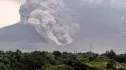 Gunung Sinabung yang mengeluarkan abu tebal terlihat dari kota Karo, Sumatera Utara (6/4). Pusat vulkanologi memperkirakan masih akan terjadi erupsi susulan. (AFP Photo/Anto Sembiring)